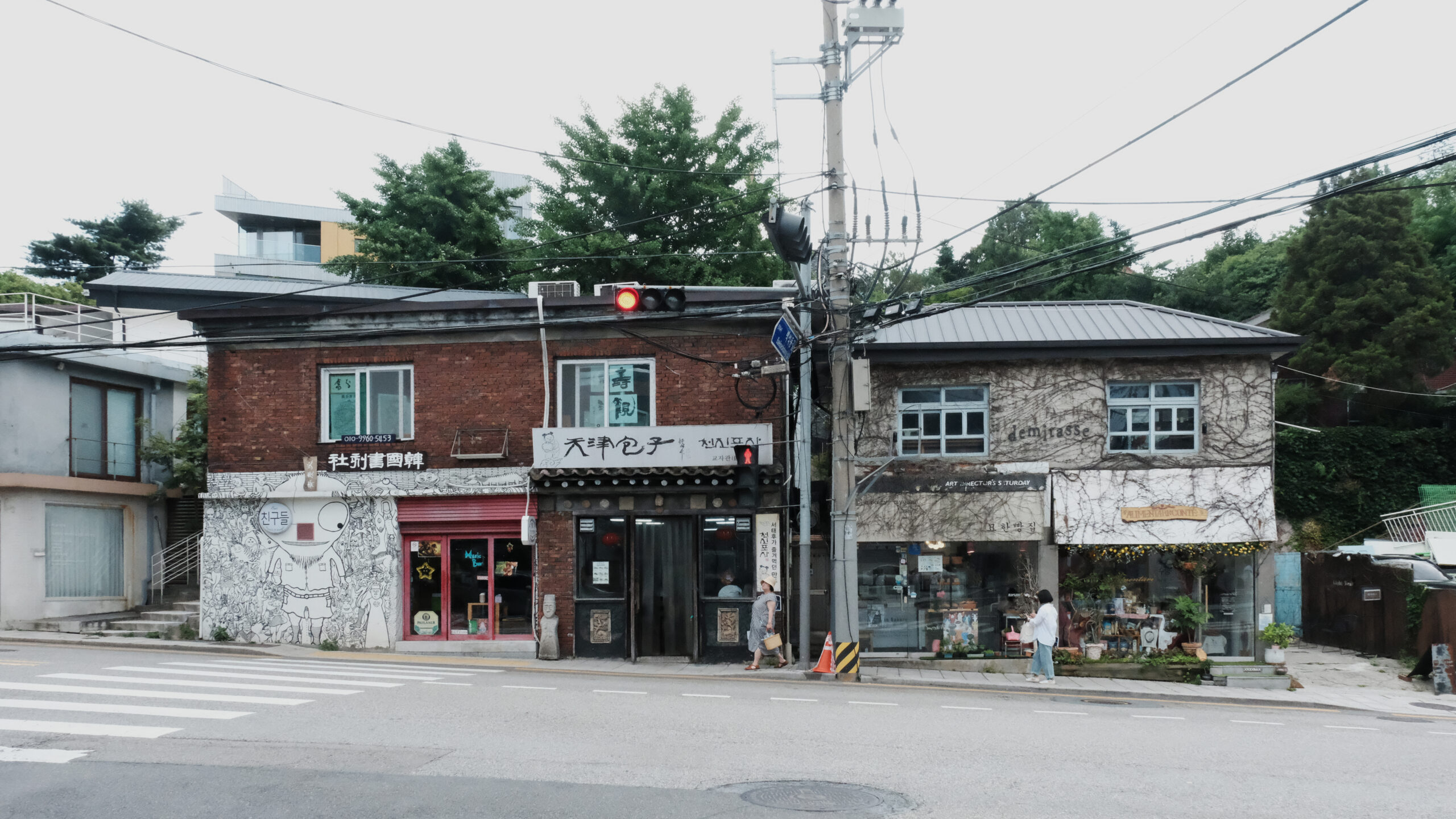 중국 만두 전문점 '천진포자'와 담쟁이덩굴이 덮인 '데미타스' 건물이 나란히 위치한 부암동 도로변 상점가 풍경