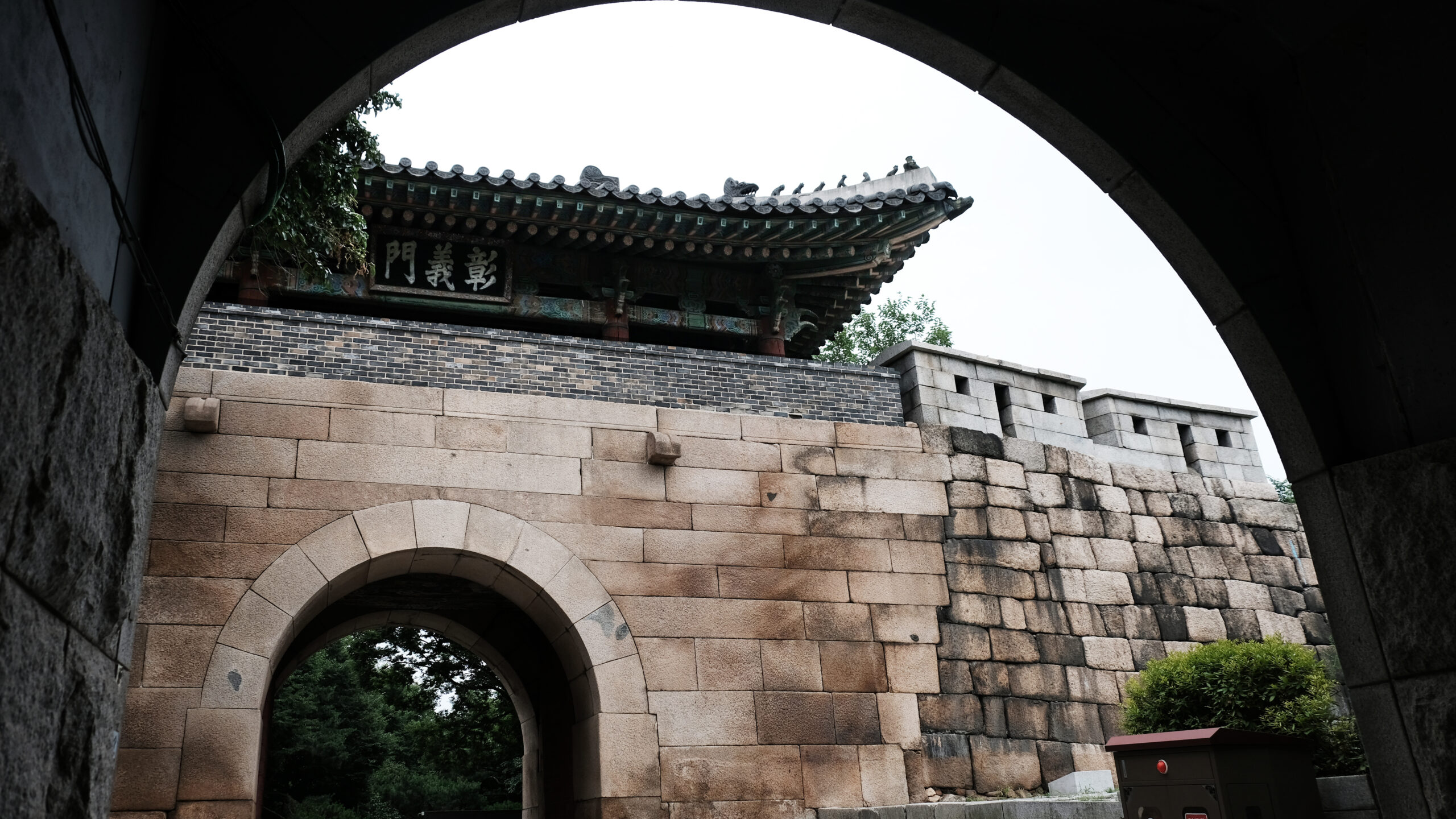 석조 아치형 통로(홍예문) 너머로 보이는 창의문의 웅장한 누각과 조선시대의 고색창연한 성벽 전경