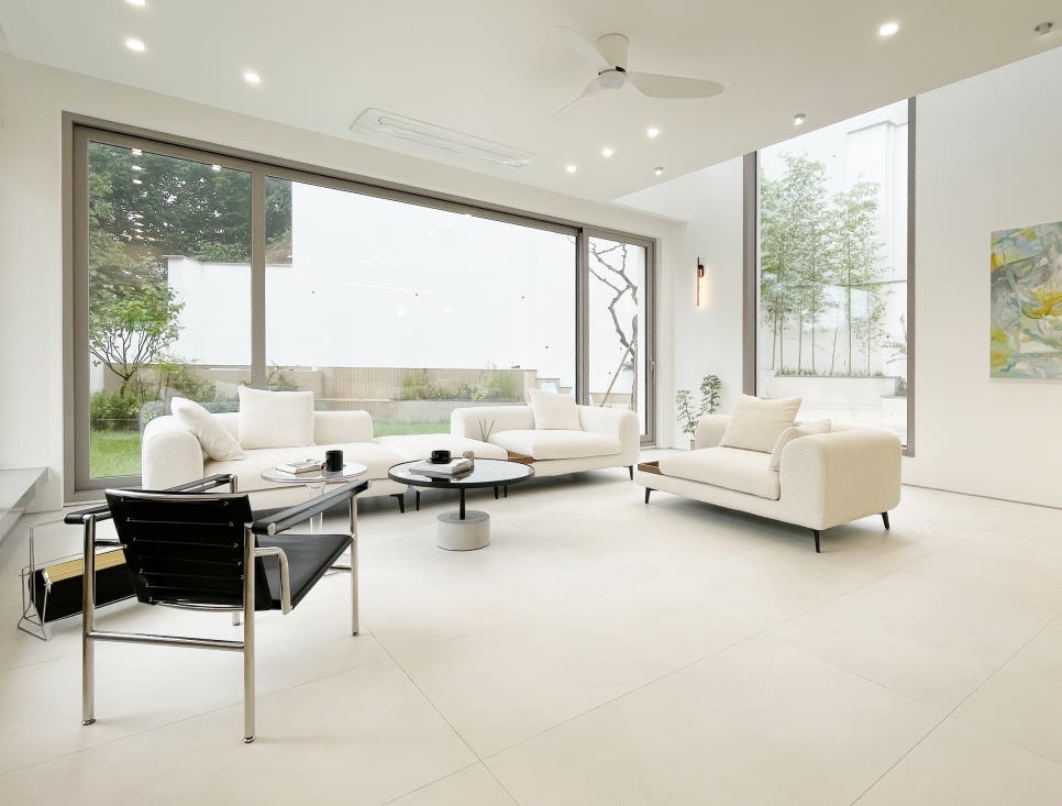 묵화담 1층 거실 인테리어: 통창으로 정원과 연결되는 화이트 톤의 모던 환대 공간과 가구 스타일링