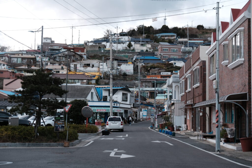 목포 서산동 시화골목 마을 입구에서 바라본 거리 전경. 유달산 가파른 비탈면을 따라 층층이 들어선 주택들과 복잡하게 얽힌 전신주가 보인다. 근대 항구도시 목포의 독특한 주거 형태와 산동네의 지형적 특징을 한눈에 볼 수 있는 풍경이다.