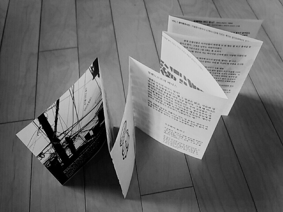 나무 바닥 위에 지그재그로 세워진 독립잡지 잼이로 창간호의 아코디언 병풍 접지 내부 지면