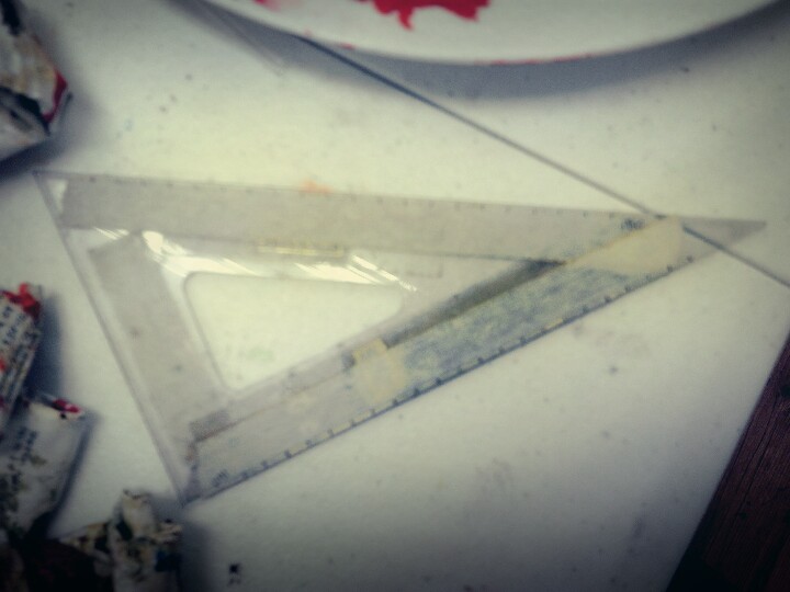 잉크 자국과 테이핑 흔적이 남은 낡고 투명한 플라스틱 삼각자